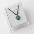 Green aventurine gemstone cat paw pendant necklace with brown braided cord in clear jewelry box. - Green Aventurine