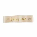 Detail shot of champagne bridesmaid sash with gold foil text and hearts for wedding party. - Bridesmaid
