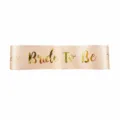 Champagne satin bachelorette party sash detail featuring gold foil Bride To Be lettering. - Bride To Be