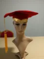 Red graduation cap variant with gold trim and yellow tassel for school ceremony celebration. - Red Gold Edge