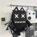 Black cartoon school backpack with cool XX eyes design, lightweight travel daypack for daily use. - Black With Pendant