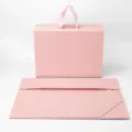 Pink collapsible gift box with ribbon handles and magnetic closure, ideal for luxury packaging. - 38x28x13.5cm / Pink