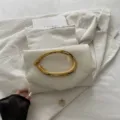 White PU leather clutch bag with sculptural gold metal handle, elegant evening party variant. - White