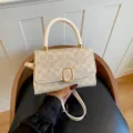 Bolso bandolera clásico con monograma, asa superior individual y elegante herraje dorada. - Blanco