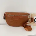 Brown woven leather crescent crossbody bag detail, featuring durable metallic zipper and strap. - Brown