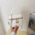 Detailed view of the white quilted vanity bag with golden chain strap and hardware. - Off White