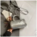 Borsa a tracolla a cuscino argentata da donna, borsa metallica alla moda con grazioso ciondolo orsetto. - Argento