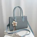 Elegante blaue Damen Umhängetasche aus Canvas mit Henkel und hübschem Blumen-Anhänger. - Mit Anhänger / Blau