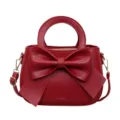 Red leather handbag with a large bow, top handle and shoulder strap for women stylish daily. - Red