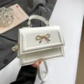 Petit sac à main carré blanc avec nœud doré élégant, sac bandoulière décontracté pour femme. - Blanc