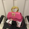 Rosa Schleifentasche mit goldenem Griff, stilvolle Schulter- und Umhängetasche für Damen. - Rosa