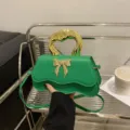 Élégant sac à main vert chic avec poignée dorée artistique et nœud pour femmes. - Vert