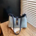 Chique denim schoudertas voor dames, stijlvolle okseltas met metalen gesp en lederen afwerking. - Denim Blauw Zonder Hanger