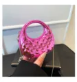 Nahaufnahme einer rosa durchsichtigen Acryl-Minihandtasche mit Steppdesign und Kette. - Rosa
