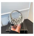 Silberne metallische Hartschalen-Handtasche mit rundem Griff und stilvollem Kettenriemen. - Silber