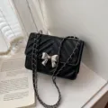 Black quilted chain shoulder bag with elegant silver bow, stylish crossbody bag for women. - Black