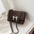 Dark brown quilted chain crossbody bag with silver bow accent, elegant luxury style for women. - Coffee