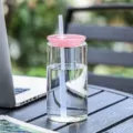 Transparent glass cup with pink lid and straw, stylish portable drinkware for office and daily use. - Pink