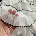 Detalle en primer plano de ribete de encaje de hilo blanco con borde negro para manualidades. - 3.8CM / Beige con borde negro