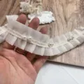 Detalle de primer plano de ribete de encaje de gasa plisada blanca con perlas para bricolaje. - Ancho 4cm / Beige