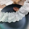 Detalle de ribete de encaje plisado bordado de flores huecas blancas para decoracion DIY. - Blanco