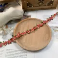 Close up detail of colorful 3d floral embroidered lace trim for diy sewing crafts. - Red