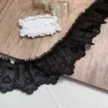 Detalle del encaje plisado bordado con corazones negros para costura y manualidades. - Negro