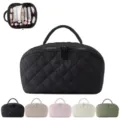 Quilted travel cosmetic bag with compartments and top handle for makeup storage and organization. - Black