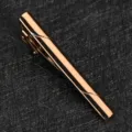 Vue détaillée de l'élégante pince à cravate en cuivre or rose pour homme, design simple. - Champagne