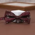 Burgundy floral pattern bow tie detail shot, elegant groom wedding suit accessory. - Sunken Flower Burgundy Bowtie
