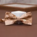 Close-up shot of a chic champagne gold patterned bow tie with delicate floral jacquard detail. - Floating Light Dream Weaving Bow Tie