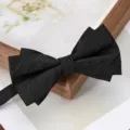 Black bow tie detail featuring multi-layer pleated texture and elegant wooden frame background. - Black Bold Stripe Bowtie