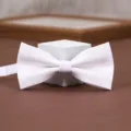 White textured bow tie detail shot, elegant fabric for men's formal suit wedding wear. - White