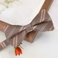 Gros plan sur le détail du nœud papillon rayé marron, texture de tissu élégante pour costumes. - Nœud Papillon Rayé Double Or de Luxe