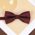 Detailed close-up shot of a classic burgundy bow tie with fine texture for men's formal wear. - Stable Wine Red Bowtie
