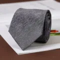 Dettaglio cravatta texturizzata grigio scuro classica, elegante accessorio formale. - Annodato a Mano / 8cm / Nebbia Tessere Traccia