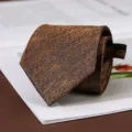 Vista ravvicinata dettagliata di un'elegante cravatta marrone con motivo a spina di pesce. - Stile con Cerniera / 8cm / Caffè Oro