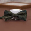 Close-up of elegant dark green bow tie featuring intricate gold floral and stripe jacquard. - Golden Lotus
