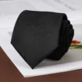 Primo piano di una cravatta nera classica strutturata che mostra un tessuto pregiato. - Annodato a Mano / 8cm / Nero