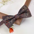 Close-up detail of a dark blue paisley bow tie with orange floral pattern for men formal suit. - Auspicious Cloud Phoenix Bowtie