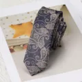 Vista detallada de la corbata estrecha azul marino con patrón de cachemira y textura fina. - Estilo Autoatado Paisley / Camel