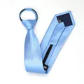 Vista de cerca de la corbata con cremallera azul claro mostrando el mecanismo y etiqueta. - Corbata Preanudada con Cremallera / 8cm / Azul Cielo Raya Fina