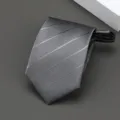 Vista detallada de la corbata gris a rayas con textura fina y práctico diseño de cremallera. - Estilo Rayado Oscuro / 8cm / Gris claro
