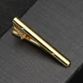 Gros plan pince a cravate doree, details rayes elegants, design classique pour costume. - Or