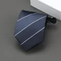 Vista detallada de una corbata a rayas azul marino con práctico cierre de cremallera. - Estilo Rayado Diagonal Ancho / 8cm / Azul marino