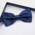 Detail shot of navy blue satin bow tie in gift box, elegant accessory for formal suits. - Navy Blue Satin Bowties