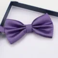 Detailed view of a stylish purple grid bow tie with fine texture inside a dark gift box. - Purple Grid Bowtie