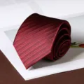 Close-up detail shot of a rolled burgundy necktie featuring fine textured diagonal stripes. - Dark Pattern Hand-Tied Style / 8cm / Dark Wine Red