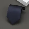 Vista detallada de una corbata a rayas azul oscuro, fina textura de tejido diagonal y cremallera práctica. - Estilo de Rayas Diagonales / 8cm / Azul marino