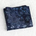 Gedetailleerd overzicht van een donkerblauwe pochet met bloemenmotief en vintage stijl voor pakken. - Egeïsche Golven Donkerblauw